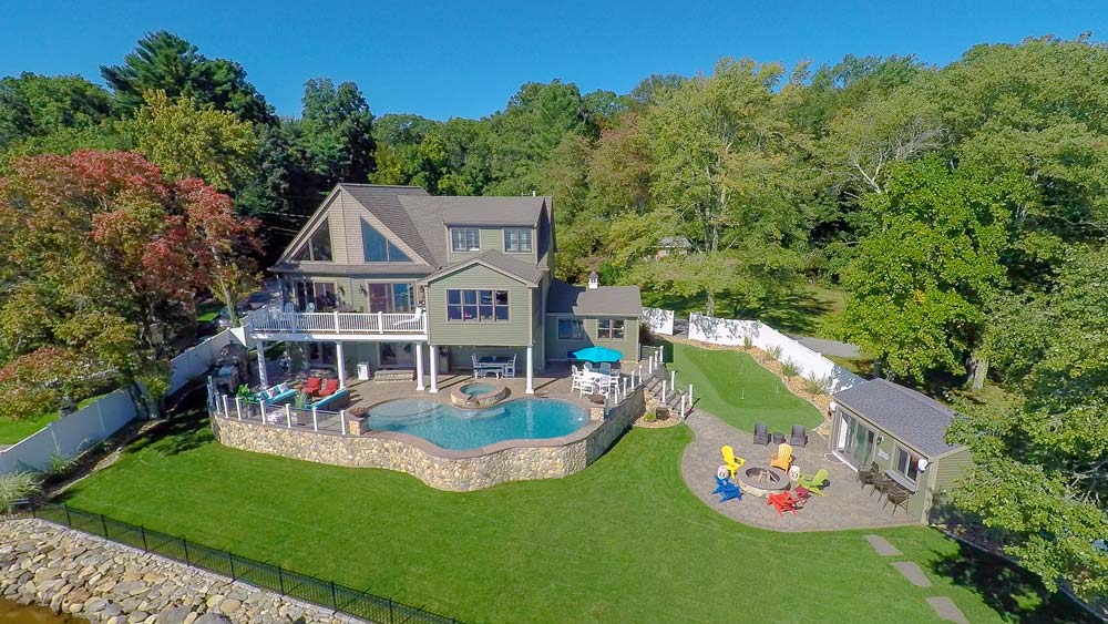 Aerial view of pool in backyard with fire pit and yard kitchen