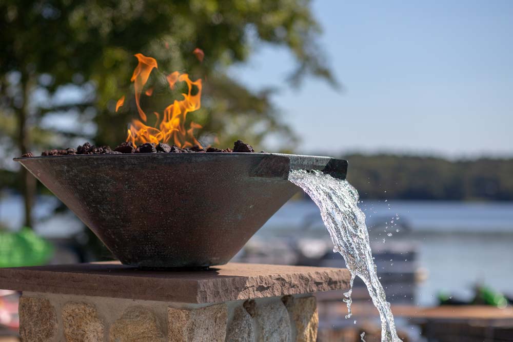 Decorative water streams with fire next to pool