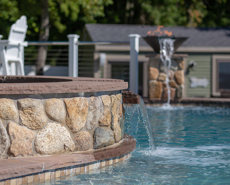 Decorative water streams next to pool