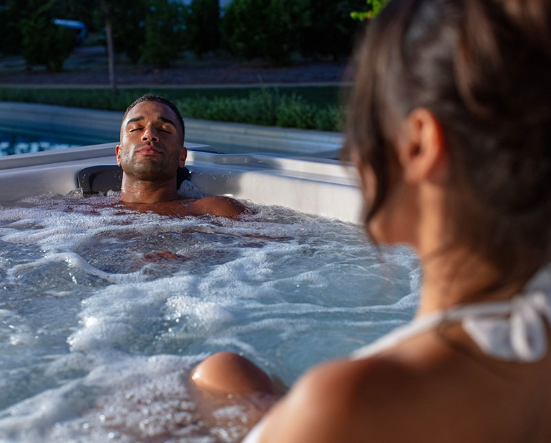 Couple enjoying hot tub at night