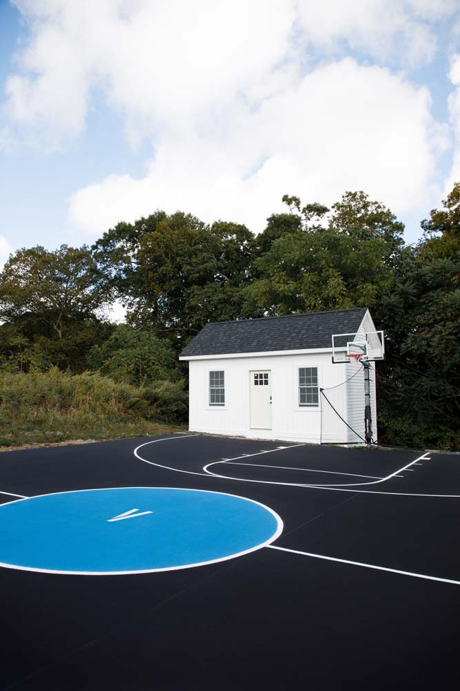 Pool house in backyard next to the basketball court